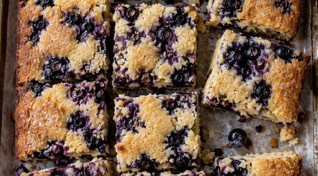 Stücke Heidelbeer-Blechkuchen direkt auf Backpapier von oben fotografiert